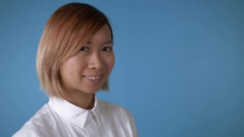 Smiling Young Woman Portrait Against Blue Background