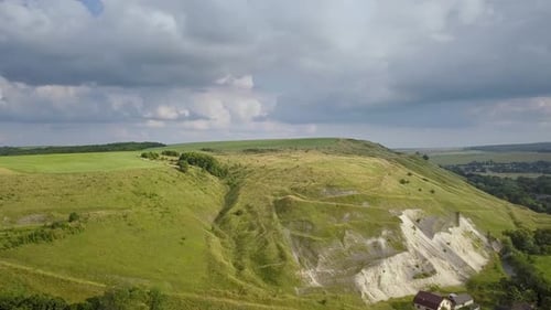 Aerial view of rural landscape. Green mountain hills with fresh meadows in summer.