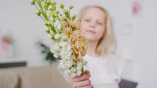 Young Girl Holds Bouquet of Flowers Indoors