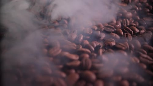 ароматные кофейные зерна в процессе обжарки с присутствием небольшого количества дыма
