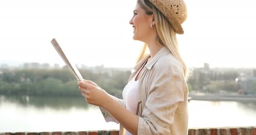 Woman Traveler with Map Smiles in a City