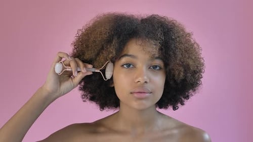Young Woman Using Facial Roller for Skincare