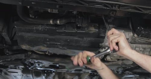 Hands Use Socket Wrench Working Under Vehicle