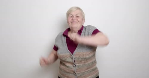 Dancing old woman. An elderly female is dancing to the music.