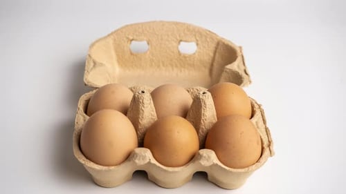 Eier erscheinen und verschwinden in einer Eierbox aus Pappe auf weißem Hintergrund. Stop-Motion-Animation