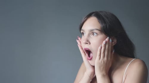 Surprised Brunette Woman Holding Face in Amazement