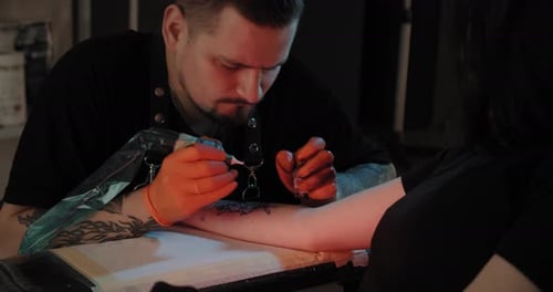 Portret Tattoo Artist zeichnet ein Bild auf die Hand, den Prozess der Erstellung eines Tattoos. Zeitlupe.