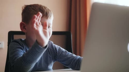 Young Boy Using Laptop at Table Indoors