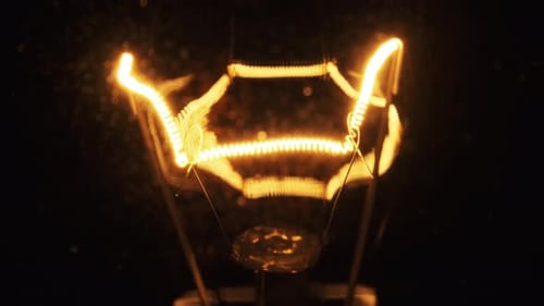 Vintage Lightbulb Filament Glowing in the Dark