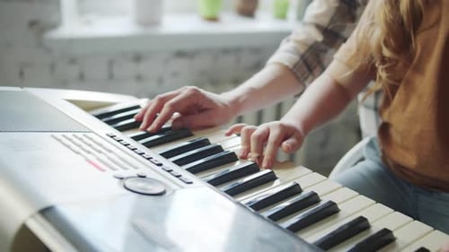 Girl and Adult Play White Electric Piano