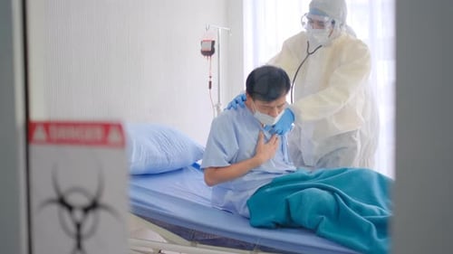 Patient in Bed Being Treated by Doctors