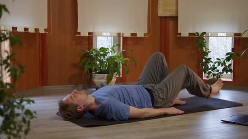 Man Doing Yoga Bridge Pose on Mat