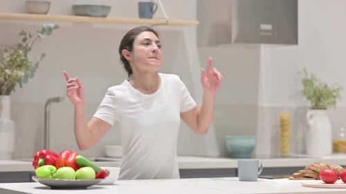 Woman Dancing Cheerfully in Modern Kitchen at Home