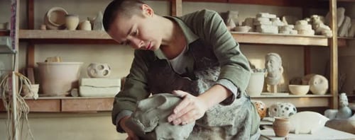 Female Sculptor Creating Clay Head in Workshop