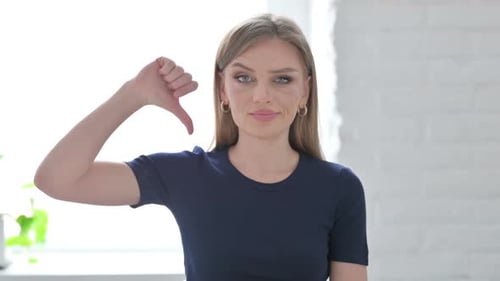 Woman Gives Thumbs Down Gesture in Studio