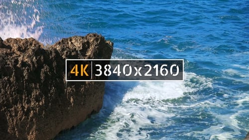 Waves Crashing Against Rocks on a Sunny Day