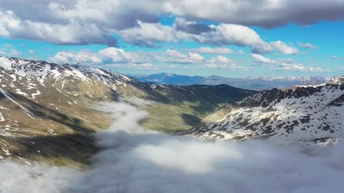 Snow Capped And Foggy Mountains