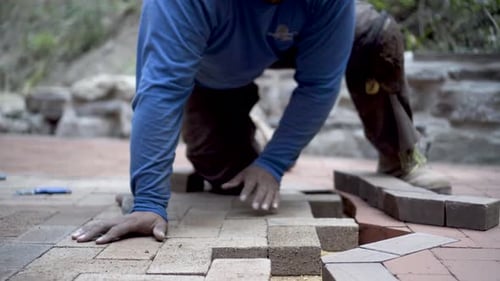Adult Installing Brick Pavers Outside