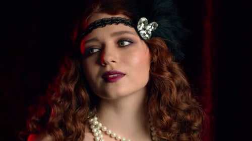 Old-fashioned Woman Dressed in Style of Flappers Posing on Dark Background. Roaring Twenties, Retro