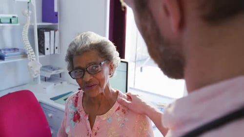 Doctor Consulting with Senior Woman in Clinic