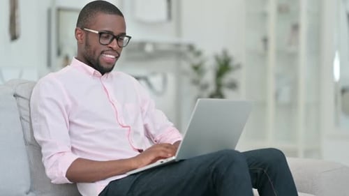 Young Adult Using Laptop and Gives Thumbs Up