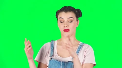 Girl with Two Hair-buns Claps Her Hands Indifferently on Green Screen. Slow Motion
