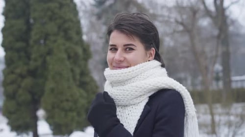 Woman Smiling in Snowy Urban Park in Winter