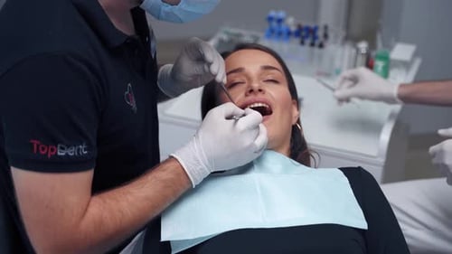 Treatment process at dental clinic. Dentist treating teeth of woman patient