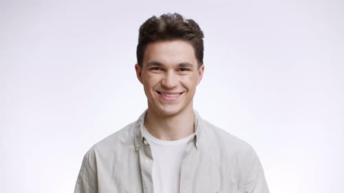 Studio Portrait of Happy Young Caucasian Man in Casual Clothes Smiling to Camera White Background