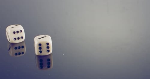 Macro disparo a cámara lenta de dados blancos cayendo y rodando sobre una superficie reflectante