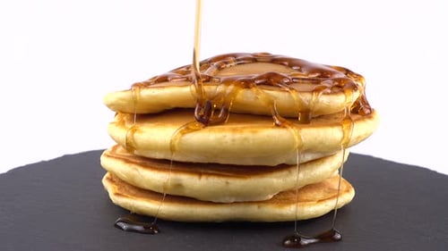 Pancakes with Maple Syrup Drizzling Close Up