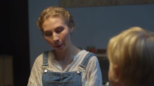 Mulher em um macacão fofo está falando com seu filho