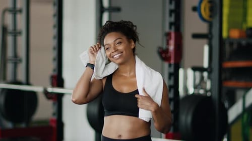 Woman Wipes Sweat After Workout at Gym