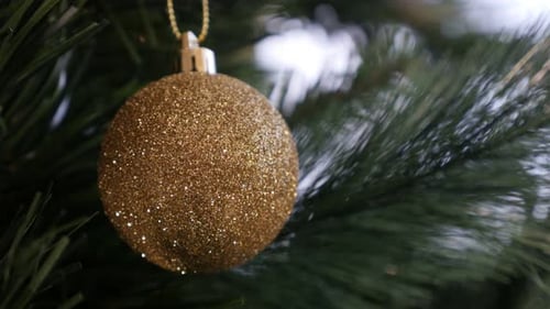 Festive Gold Christmas Ornament on Tree Close Up
