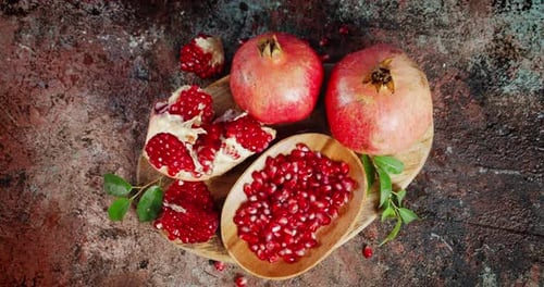 Grains of Ripe Pomegranate on Wooden Plate Rotate Slowly