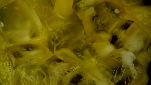 Yellow Beverage Being Poured Over Ice Cubes