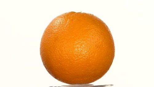 Isolated Orange Slowly Rotating on a White Background