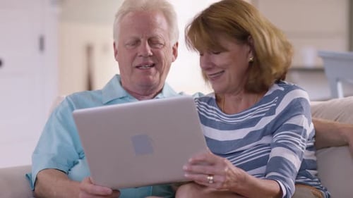 Mature Couple Relaxing at Home with Laptop