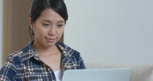 Woman Works on Laptop Computer at Home