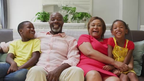 Happy Family Laughing Together on Sofa