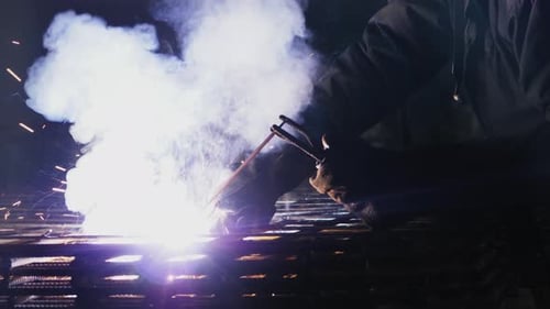 Welder Joining Steel Rebar in Dark Setting