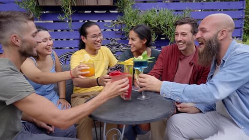 Friends Toasting Colorful Drinks at Outdoor Table