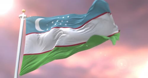 Waving Flag of Uzbekistan on a Flagpole at Sunset
