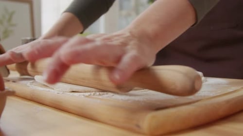 Woman Flattens Dough with Rolling Pin for Baking