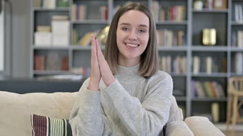 Enthusiastic Woman Clapping and Smiling on Couch