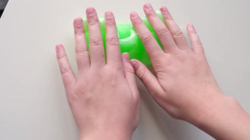 Hand Playing with Textured Slime with Bubbles Stretching