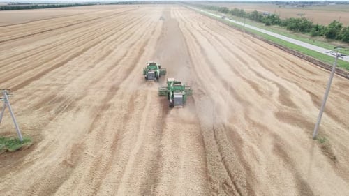 Aerial View of Harvester Machines Working in Wheat Field