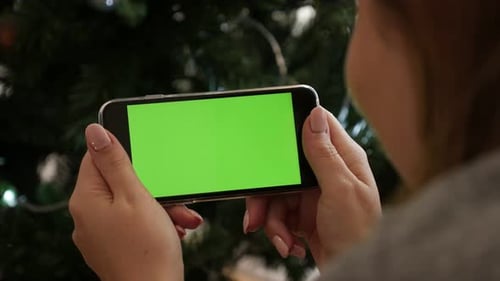 Green screen display phone at New Year night 4K 2160p 30fps UltraHD footage - Woman holds greenscree