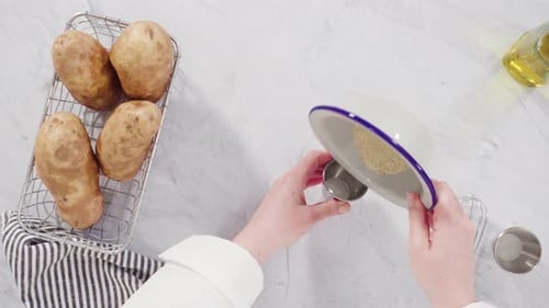 Colocação plana. Passo a passo. Ingredientes na bancada para preparar fatias de batata com especiarias.