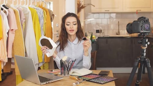 Portrait d'une jeune femme montrant les bases du maquillage devant la caméra Une blogueuse anime une émission en direct